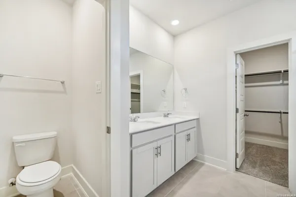 a spacious bathroom with a toilet sink and a mirror