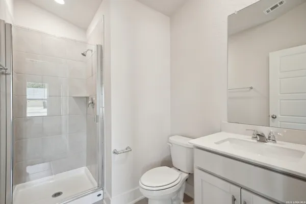 a bathroom with a granite countertop sink a toilet and shower