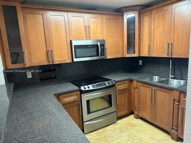 a kitchen with stainless steel appliances granite countertop a stove a washer and dryer