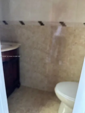 a white toilet sitting next to a shower