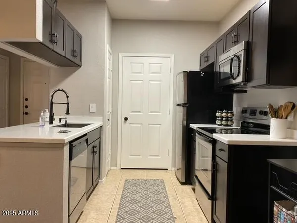 a kitchen with a sink a refrigerator and cabinets