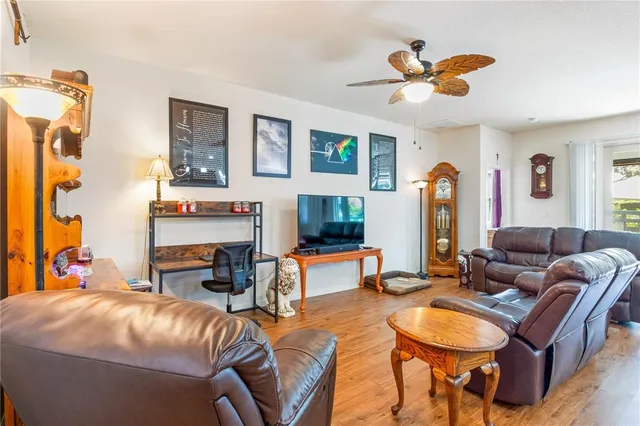 a kitchen with stainless steel appliances granite countertop wooden cabinets a refrigerator a stove a microwave and island with wooden floor