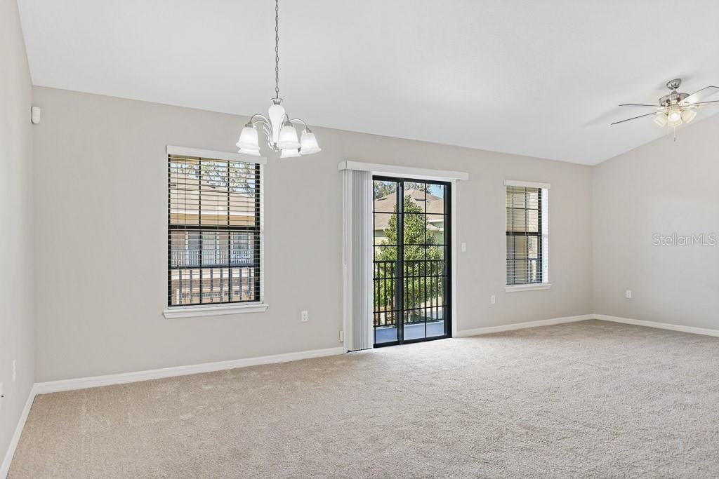 5738 Kingletsound Lithia, FL 33547 - Photo 5 of 32 an empty room with windows and chandelier fan