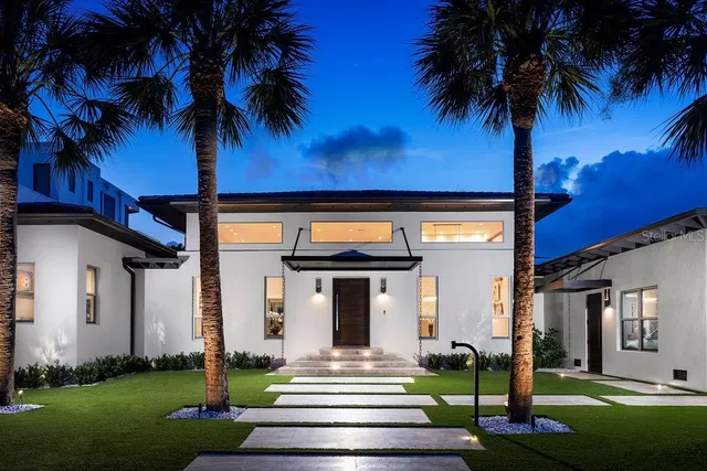 an aerial view of a house with a garden and lake view