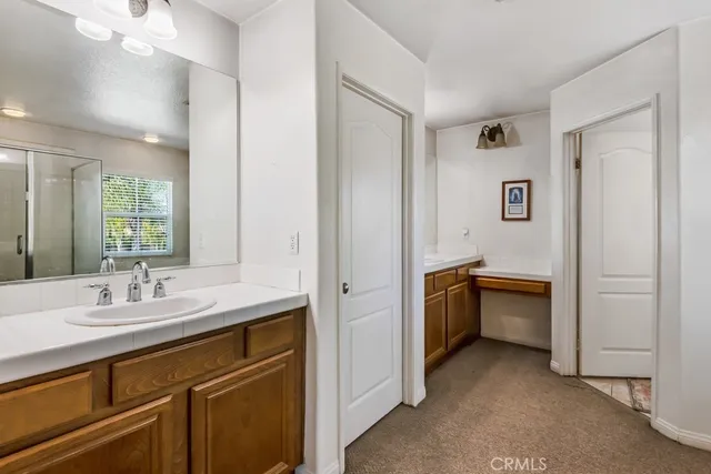 a spacious bathroom with a double vanity sink a mirror and a