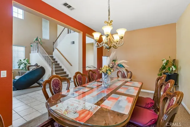 a view of a dining room with furniture a chandelier and wooden floor