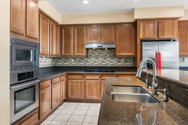 a kitchen with granite countertop a stove sink and microwave