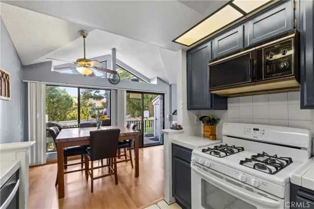 a kitchen with a stove a sink and chairs