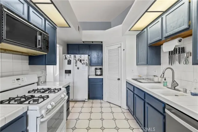 a kitchen with stainless steel appliances a stove a sink and a refrigerator