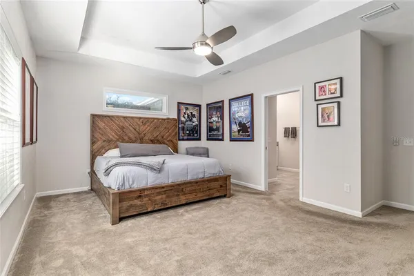 a spacious bedroom with a bed and a ceiling fan