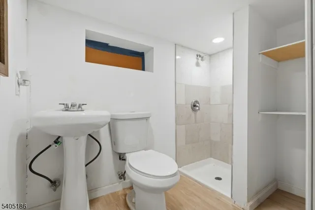 a bathroom with a shower sink mirror and toilet