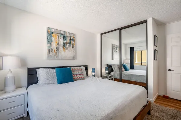a bedroom with a large bed and painting on the wall
