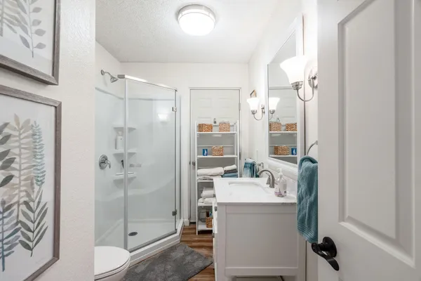 a bathroom with a sink a toilet and shower