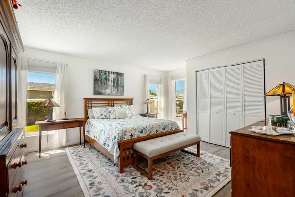 a bedroom with a bed and a dresser next to a window