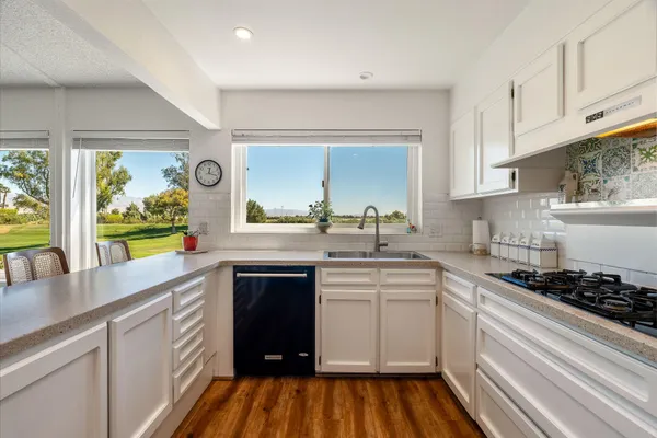 a kitchen with wooden cabinets stove and sink