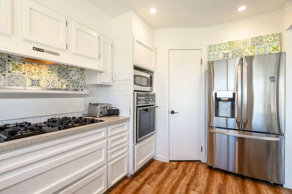 a kitchen with a refrigerator and a stove top oven