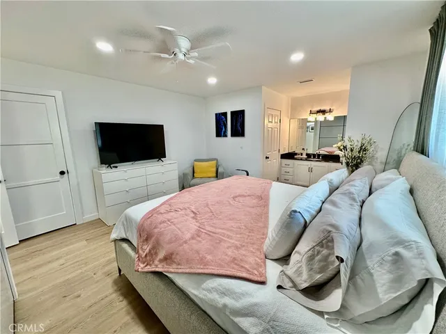 a bed room with a bed television and a large window