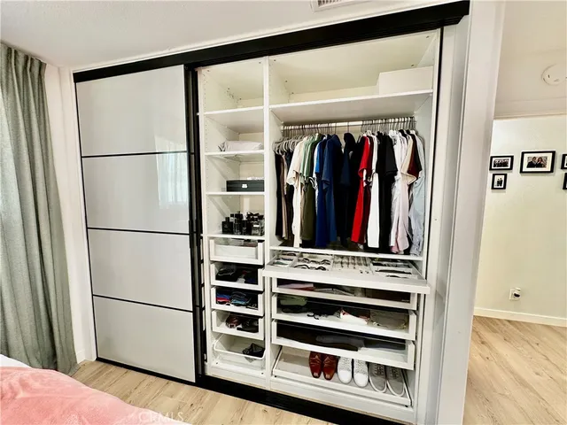 a view of walk in closet with clothes and shoes