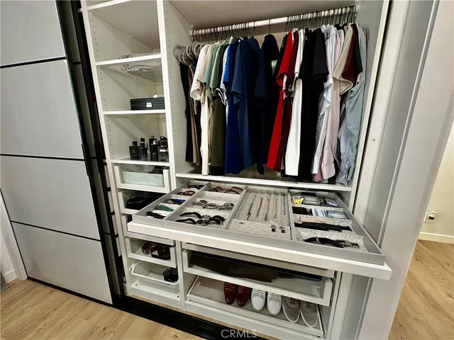 a view of walk in closet with clothes and shoes