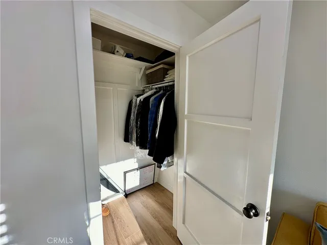 a view of walk in closet with clothes and shoes