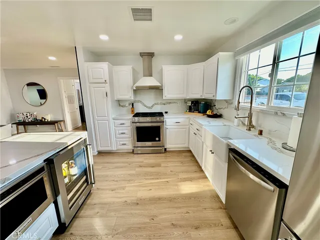a large kitchen with stainless steel appliances granite countertop a sink stove and refrigerator