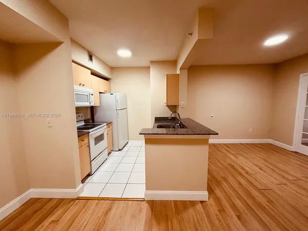 a kitchen with granite countertop white cabinets and stainless steel appliances