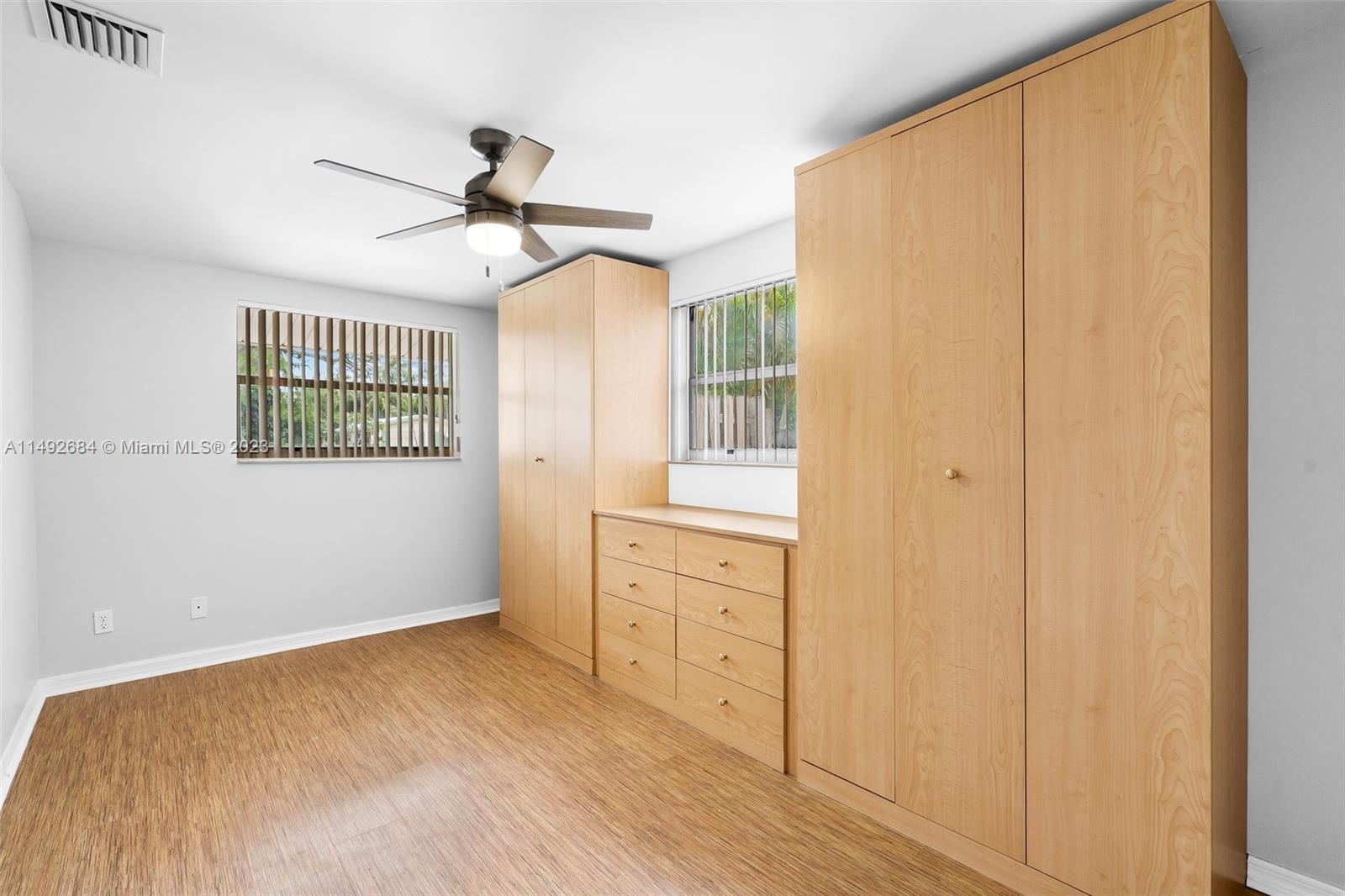 5893 Williamson Road Jupiter, FL 33458 - Photo 18 of 31 a view of a bedroom with wooden floor closet and windows