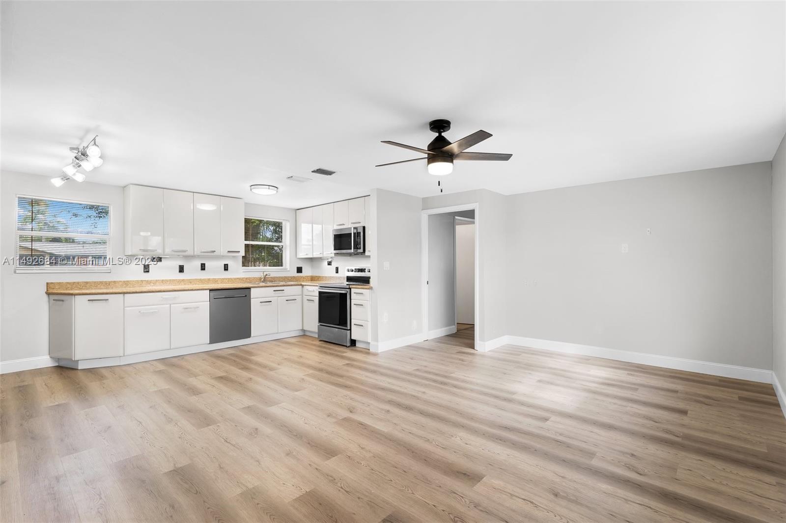 5893 Williamson Road Jupiter, FL 33458 - Photo 2 of 31 a view of kitchen with white cabinets appliances and chandelier
