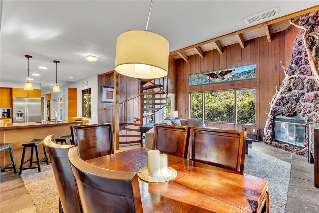 53580 Jeffery Pine Road Idyllwild, CA 92549 - Photo 14 of 61 a dining room with furniture a fireplace and a chandelier