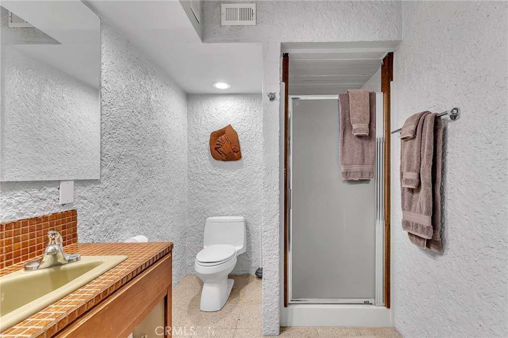 53580 Jeffery Pine Road Idyllwild, CA 92549 - Photo 24 of 61 a bathroom with a granite countertop sink a toilet and shower