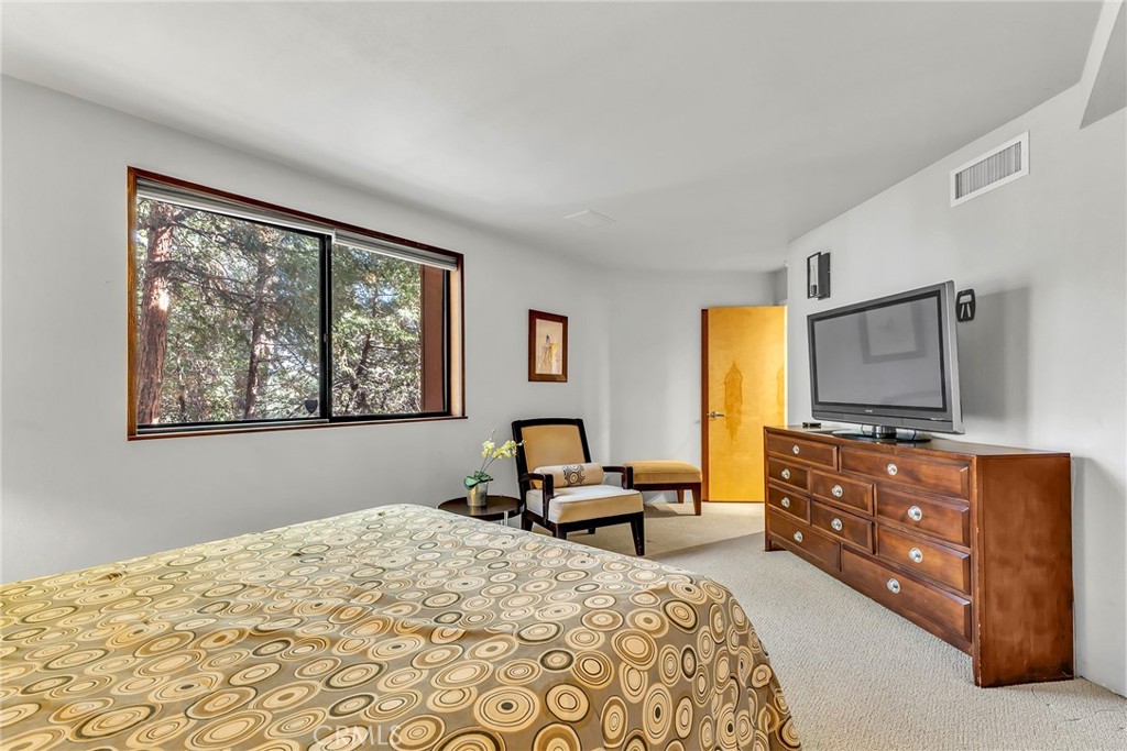 53580 Jeffery Pine Road Idyllwild, CA 92549 - Photo 26 of 61 a bedroom with a bed and furniture with a flat tv screen