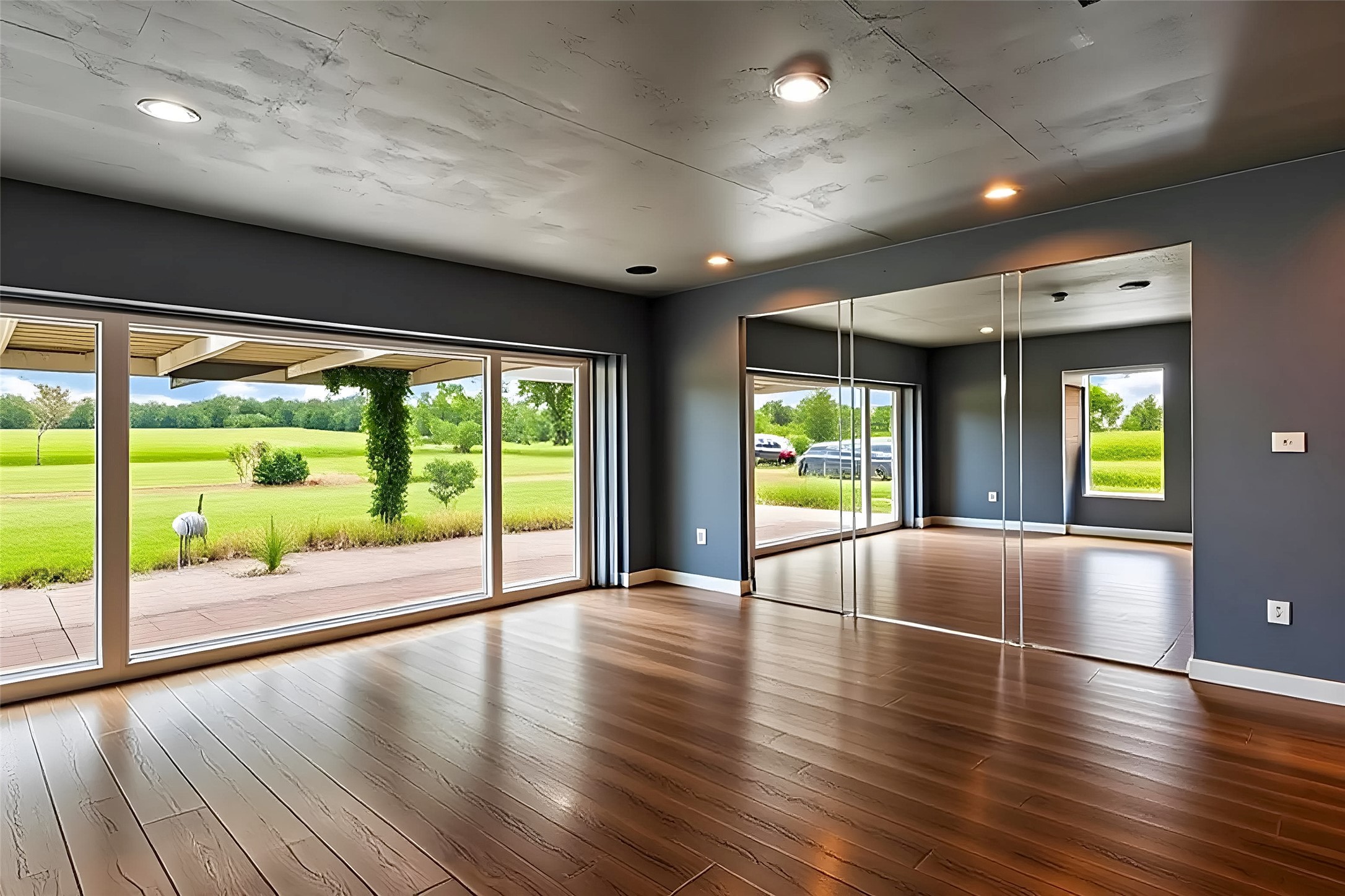 358 Easley Road Smithville, TX 78957 - Photo 31 of 36 Flex area / bedroom #4 featuring hardwood floors and walls of glass overlook a verdant landscape.