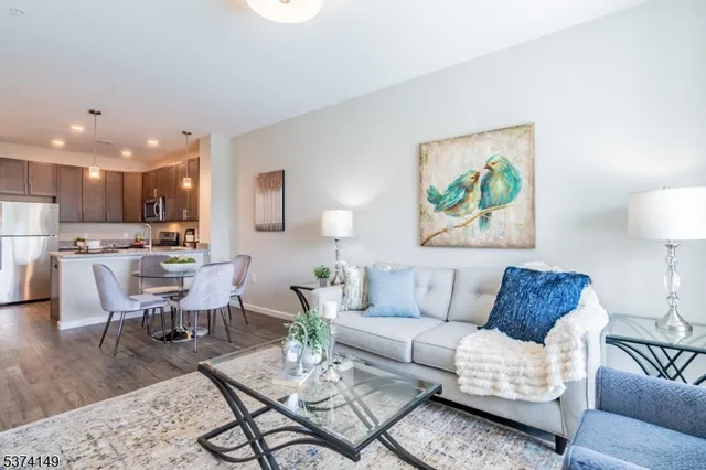 a living room with furniture kitchen view and a potted plant