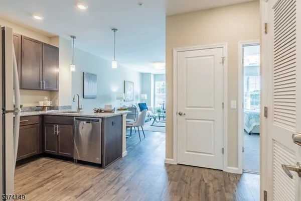 a large kitchen with a wooden floor and a refrigerator