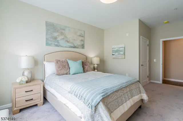 a bedroom with a bed and a lamp on the dresser