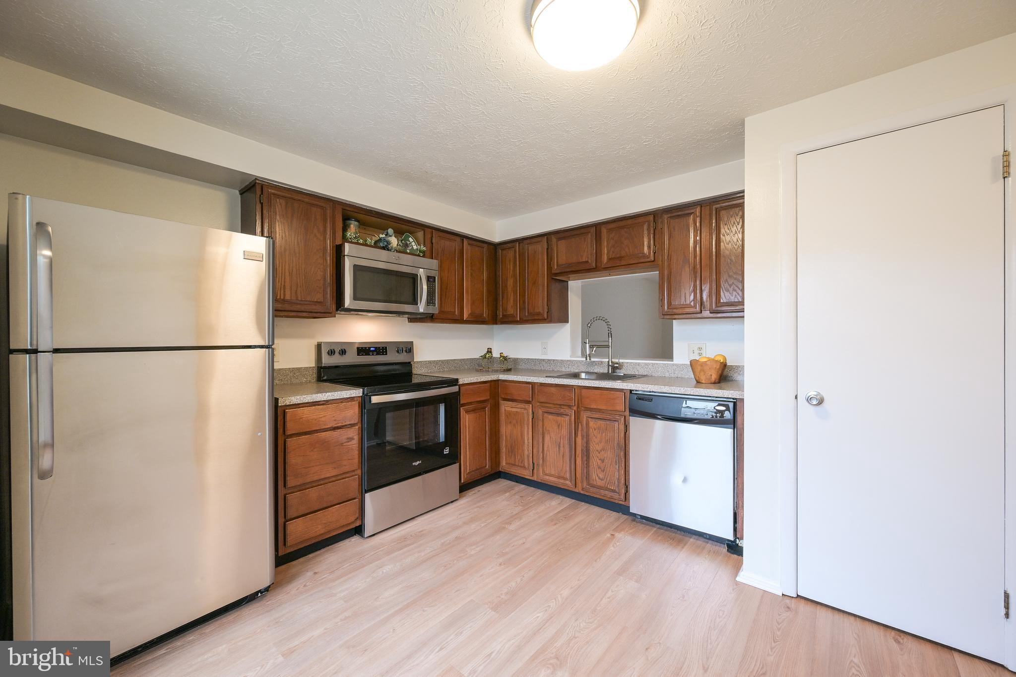 7954 Millstream Court Elkridge, MD 21075 - Photo 11 of 41 a kitchen with granite countertop a refrigerator stove top oven and sink
