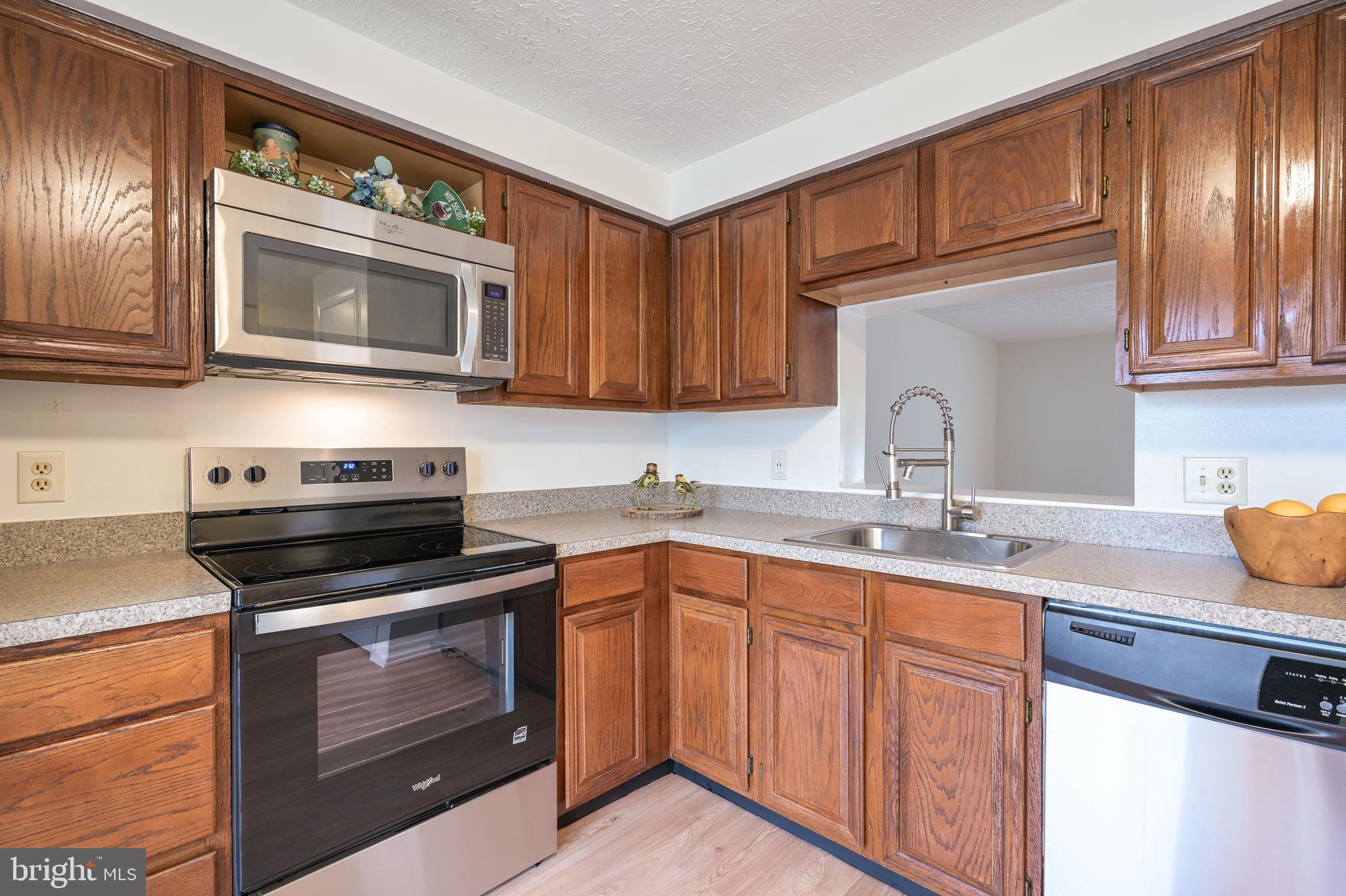 7954 Millstream Court Elkridge, MD 21075 - Photo 12 of 41 a kitchen with granite countertop a sink stainless steel appliances and cabinets
