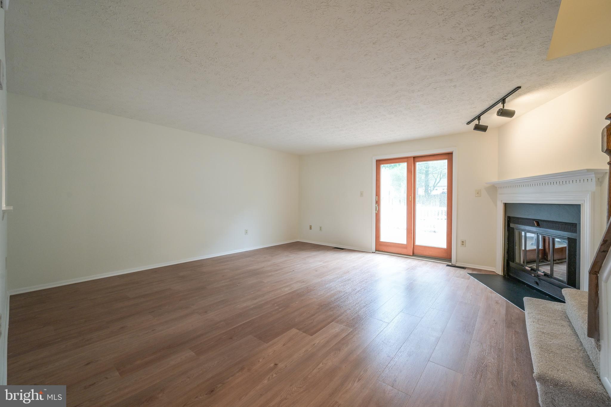 7954 Millstream Court Elkridge, MD 21075 - Photo 15 of 41 an empty room with wooden floor and fireplace