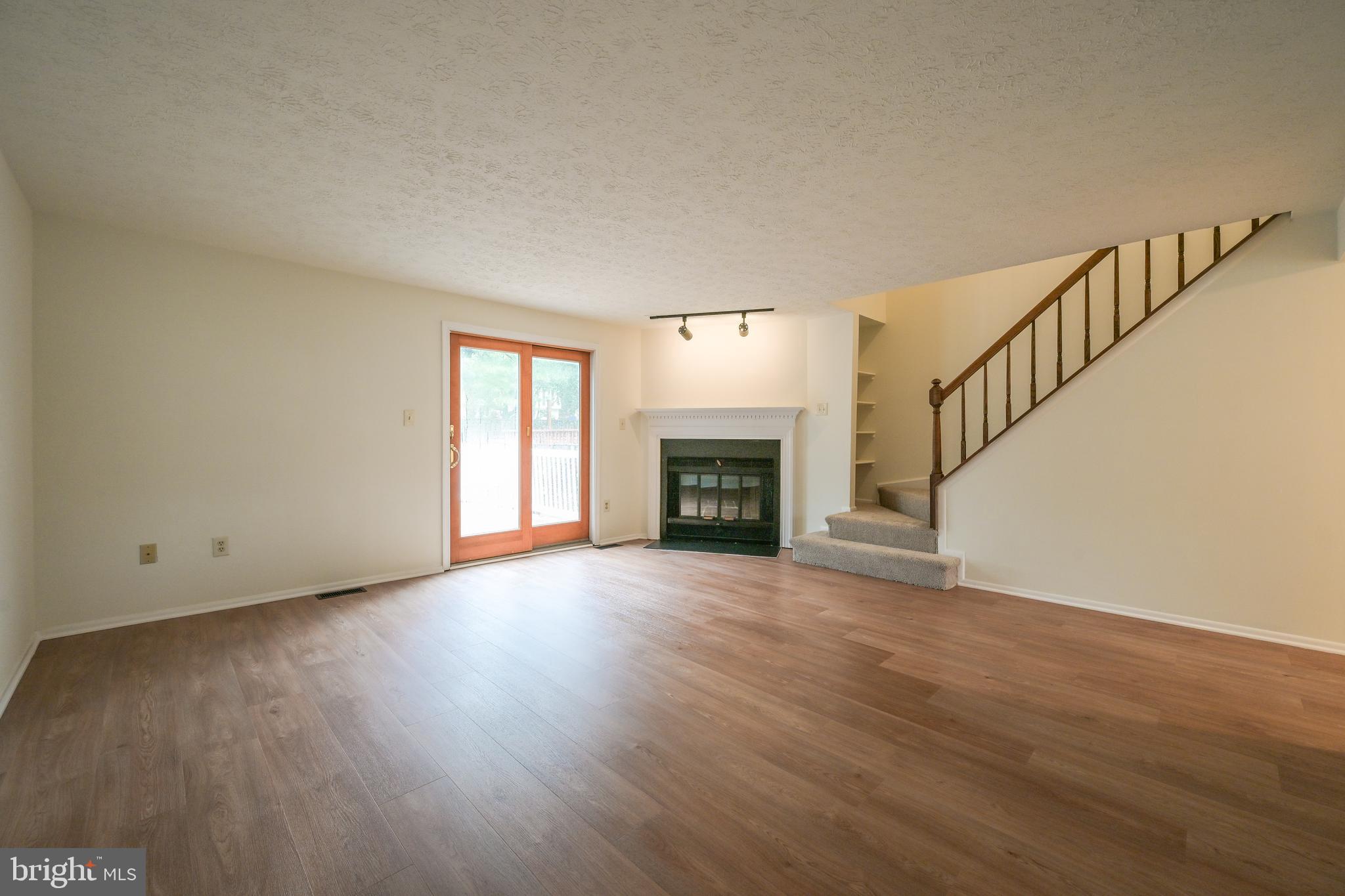 7954 Millstream Court Elkridge, MD 21075 - Photo 16 of 41 a view of an empty room with wooden floor fireplace and a window