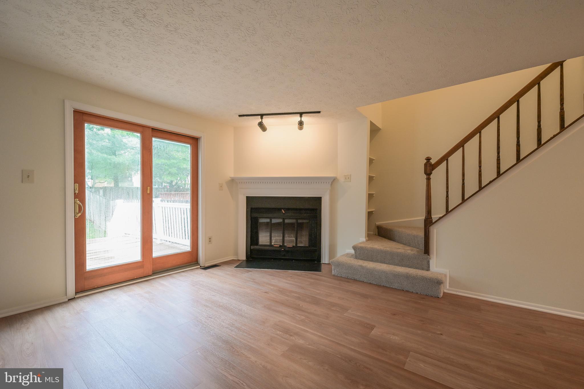 7954 Millstream Court Elkridge, MD 21075 - Photo 19 of 41 a view of an empty room with wooden floor fireplace and a window