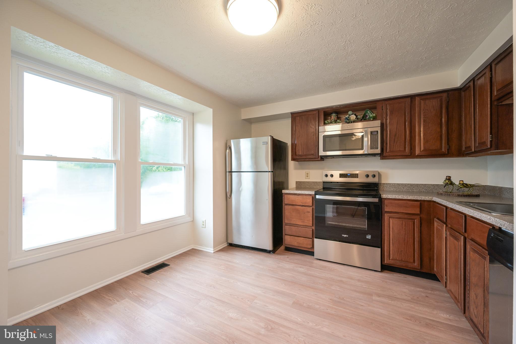 7954 Millstream Court Elkridge, MD 21075 - Photo 10 of 41 a kitchen with granite countertop a refrigerator and a stove top oven