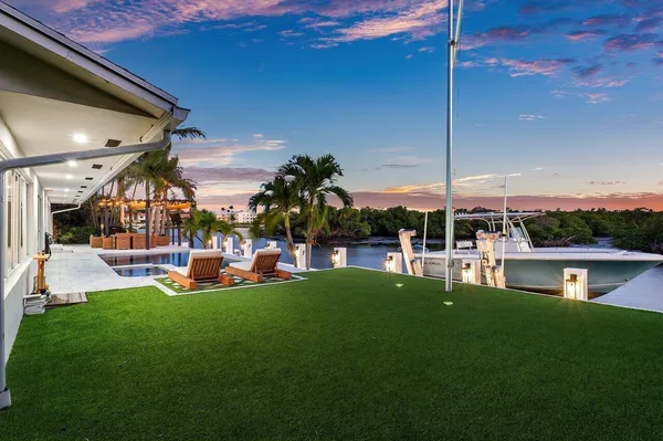 a view of swimming pool with lawn chairs and couches