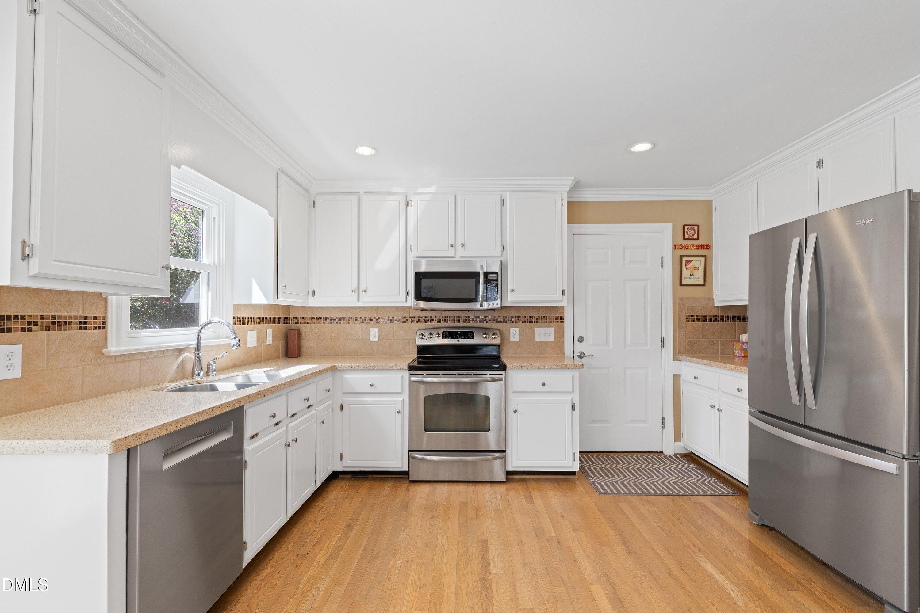501 Samara Street Apex, NC 27502 - Photo 15 of 77 a kitchen with a sink stainless steel appliances and cabinets