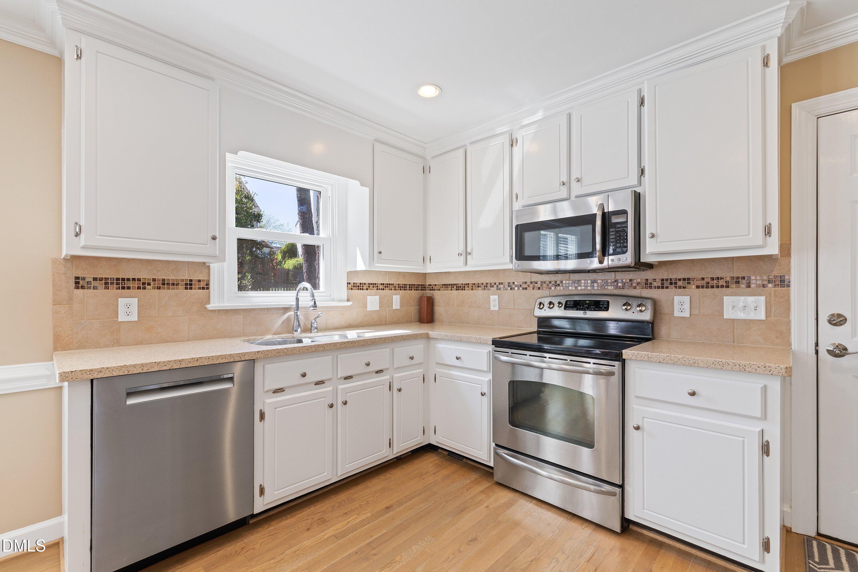 501 Samara Street Apex, NC 27502 - Photo 2 of 77 a kitchen with cabinets stainless steel appliances a sink and a window