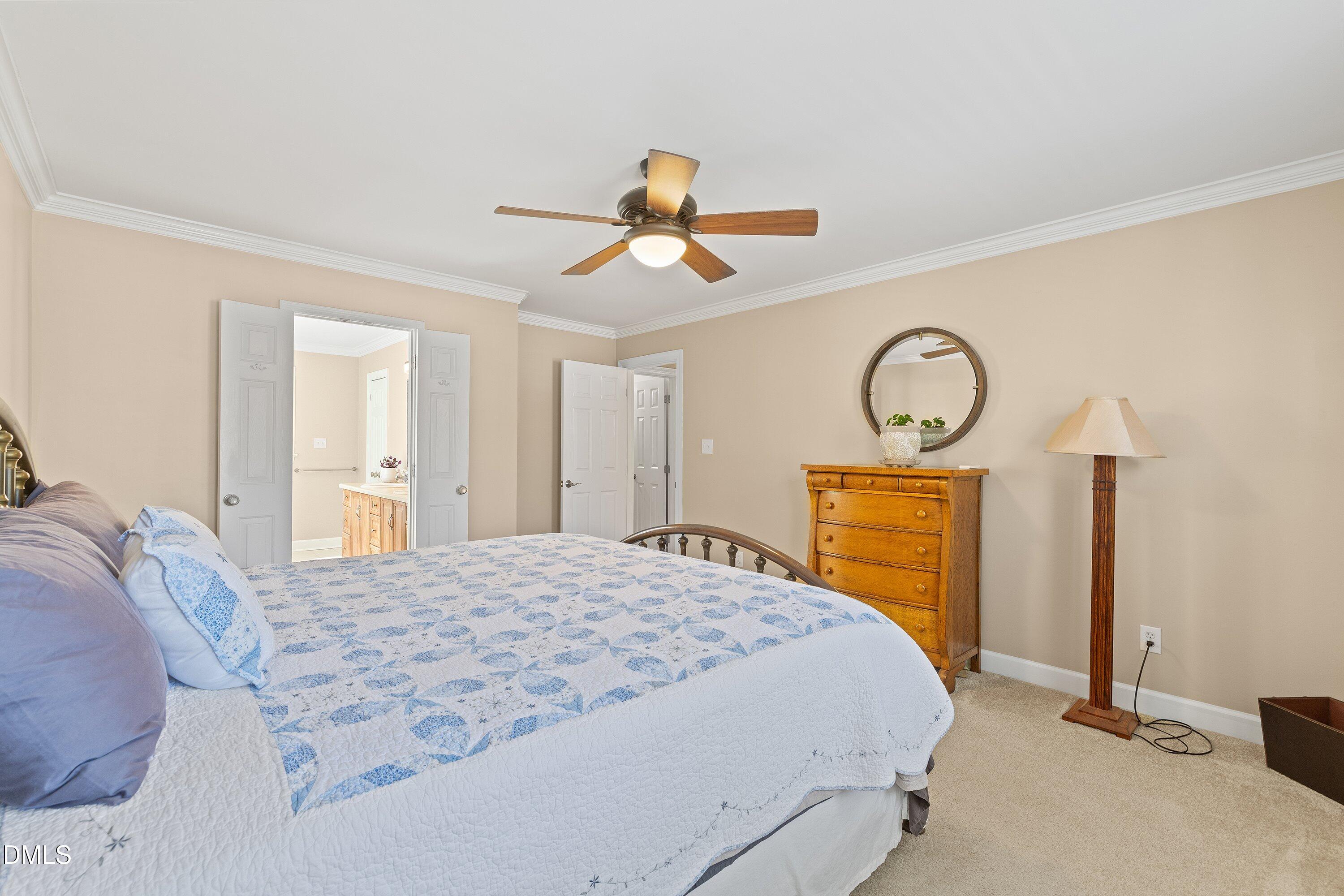 501 Samara Street Apex, NC 27502 - Photo 30 of 77 a bedroom with a bed a chandelier and dresser