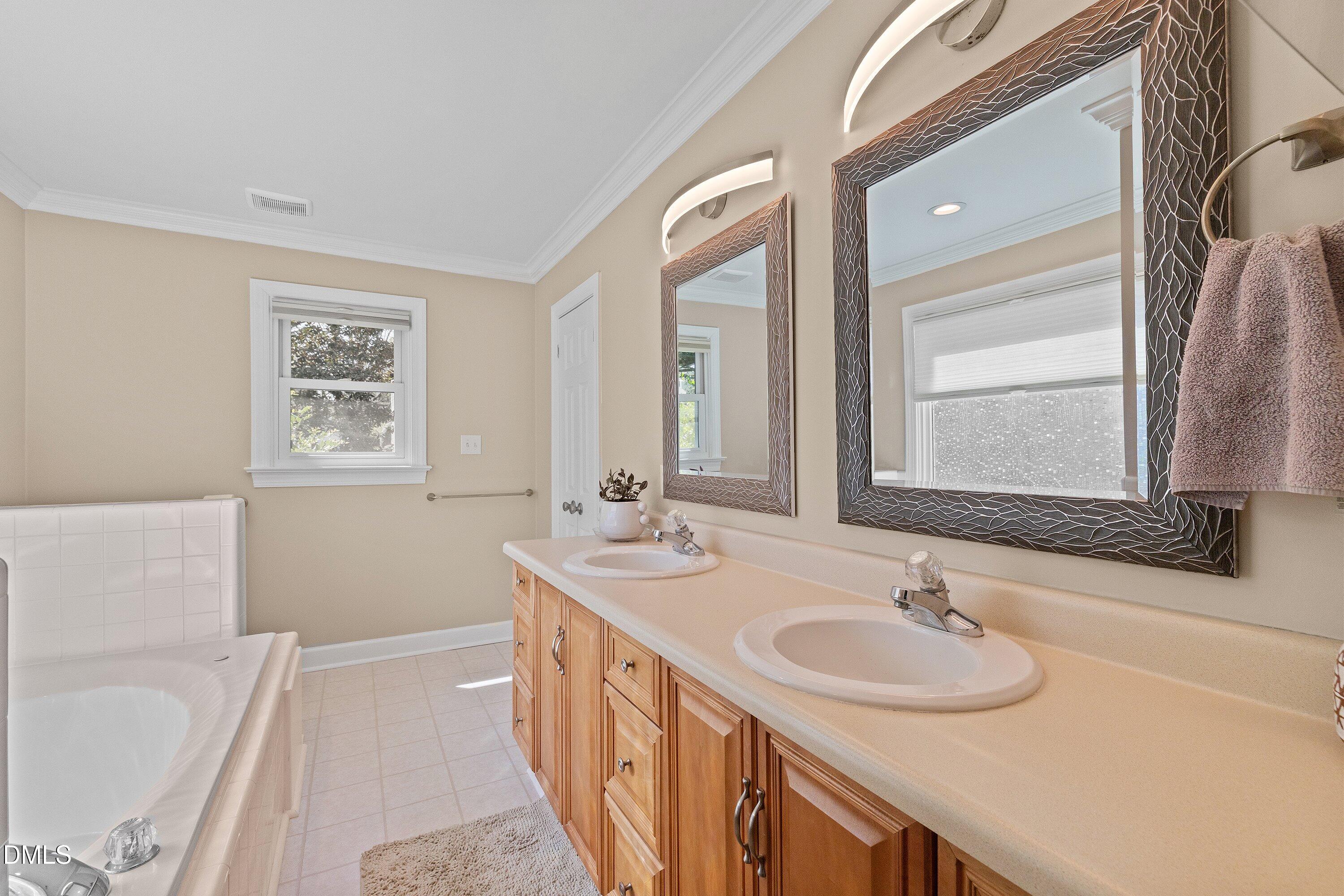 501 Samara Street Apex, NC 27502 - Photo 32 of 77 a bathroom with a sink double vanity granite tub and a mirror
