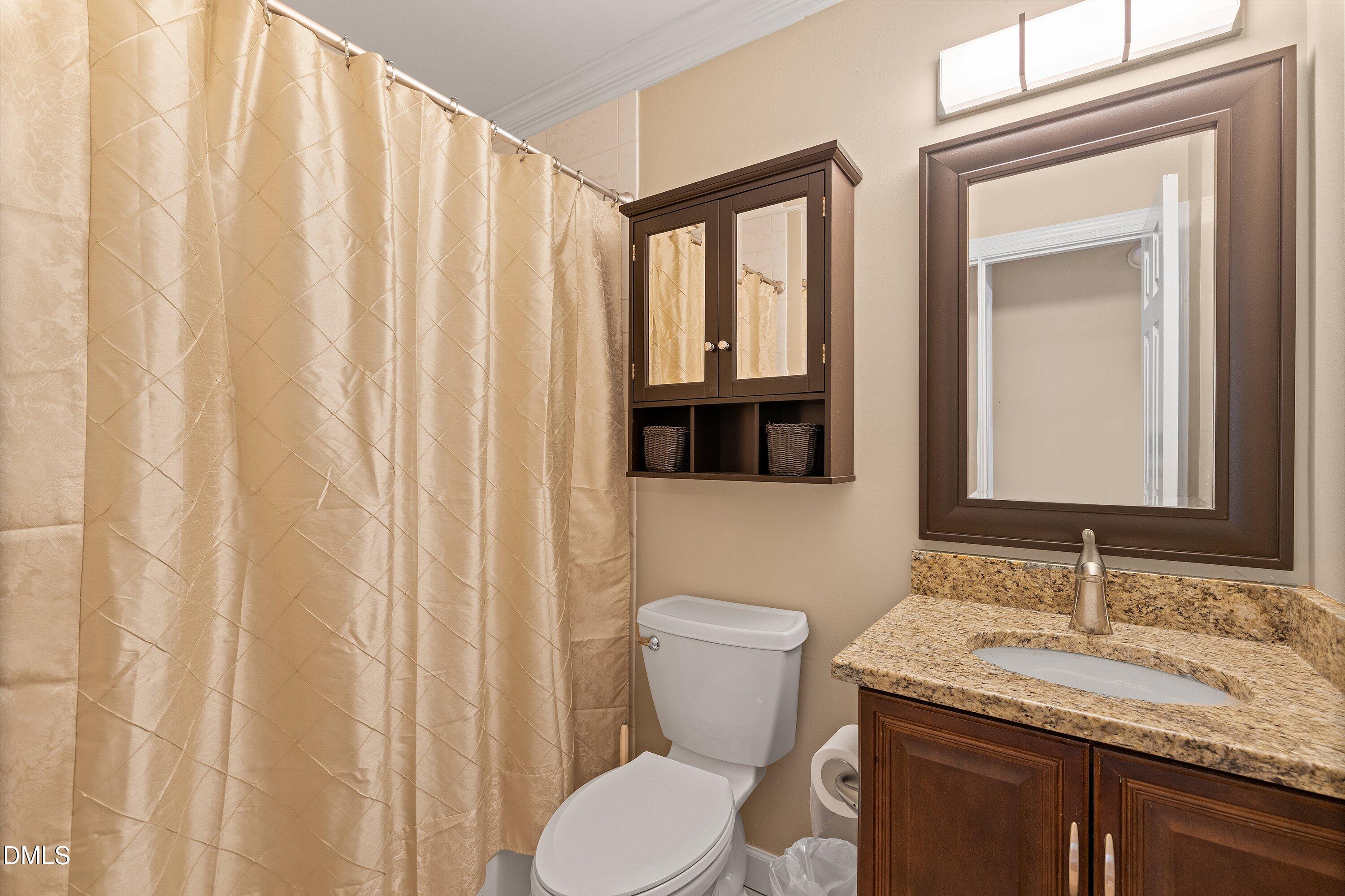 501 Samara Street Apex, NC 27502 - Photo 37 of 77 a bathroom with a granite countertop sink and a mirror
