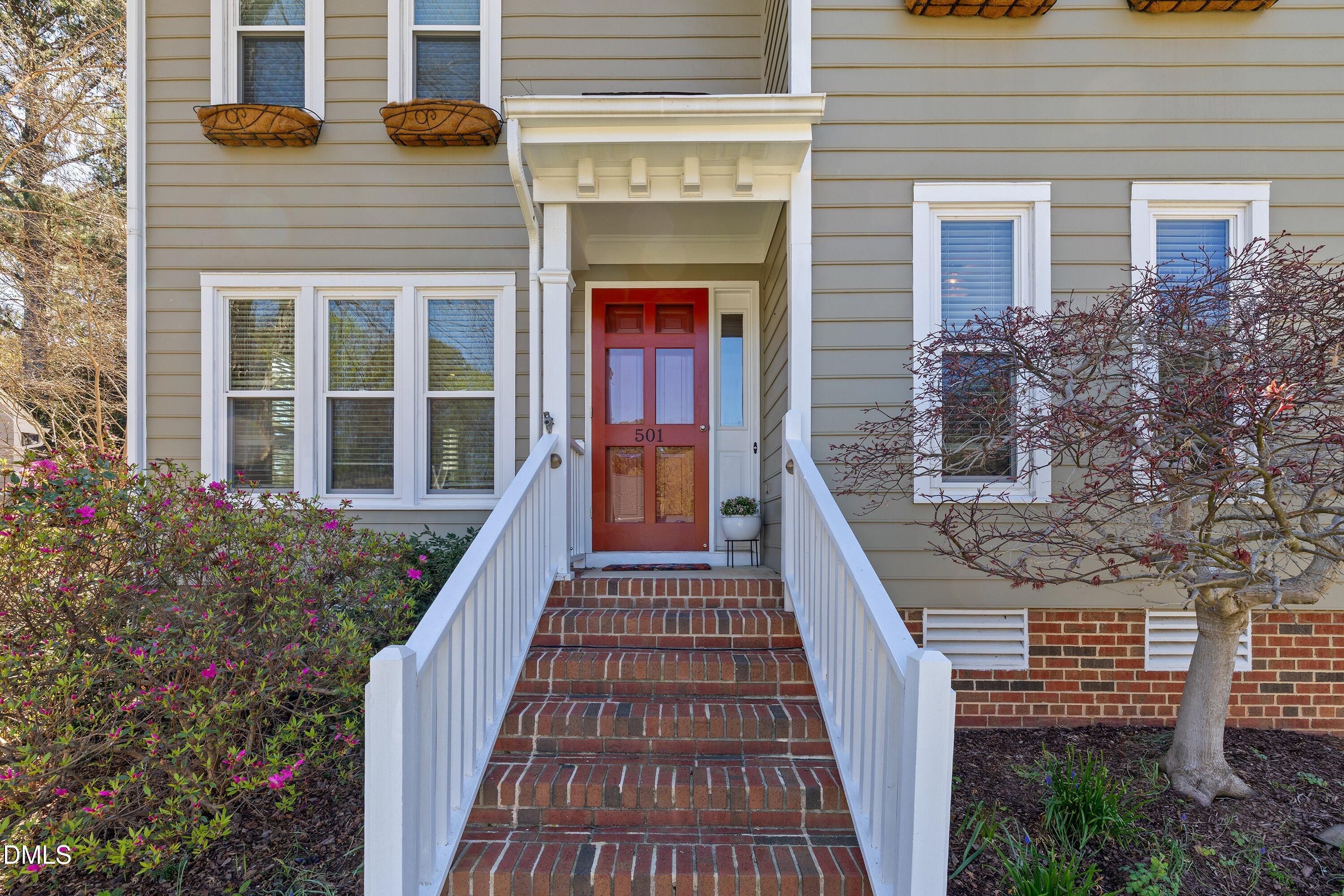 501 Samara Street Apex, NC 27502 - Photo 77 of 77 a view of a brick house with large windows and a flower plants