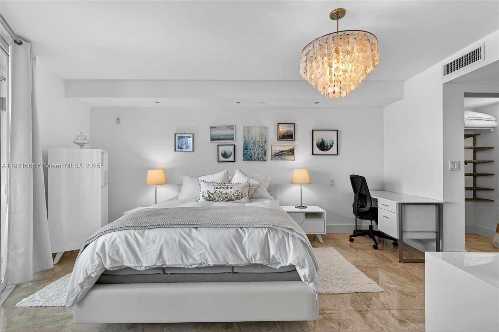 9821 East Bay Harbor Drive, Unit 402 Bay Harbor Islands, FL 33154 - Photo 14 of 34 a bedroom with a bed and a chandelier