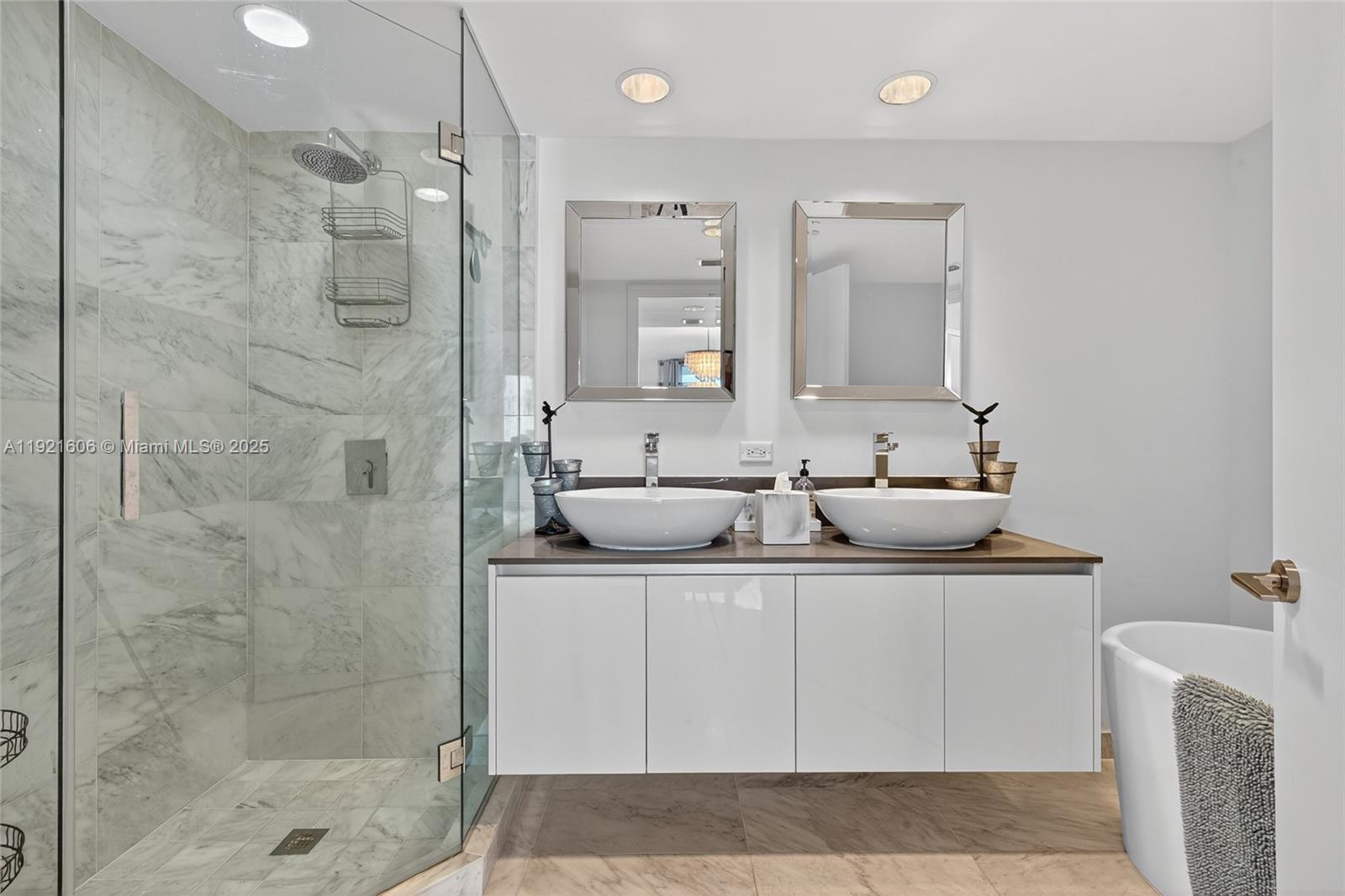 9821 East Bay Harbor Drive, Unit 402 Bay Harbor Islands, FL 33154 - Photo 16 of 34 a bathroom with a sink mirror and shower